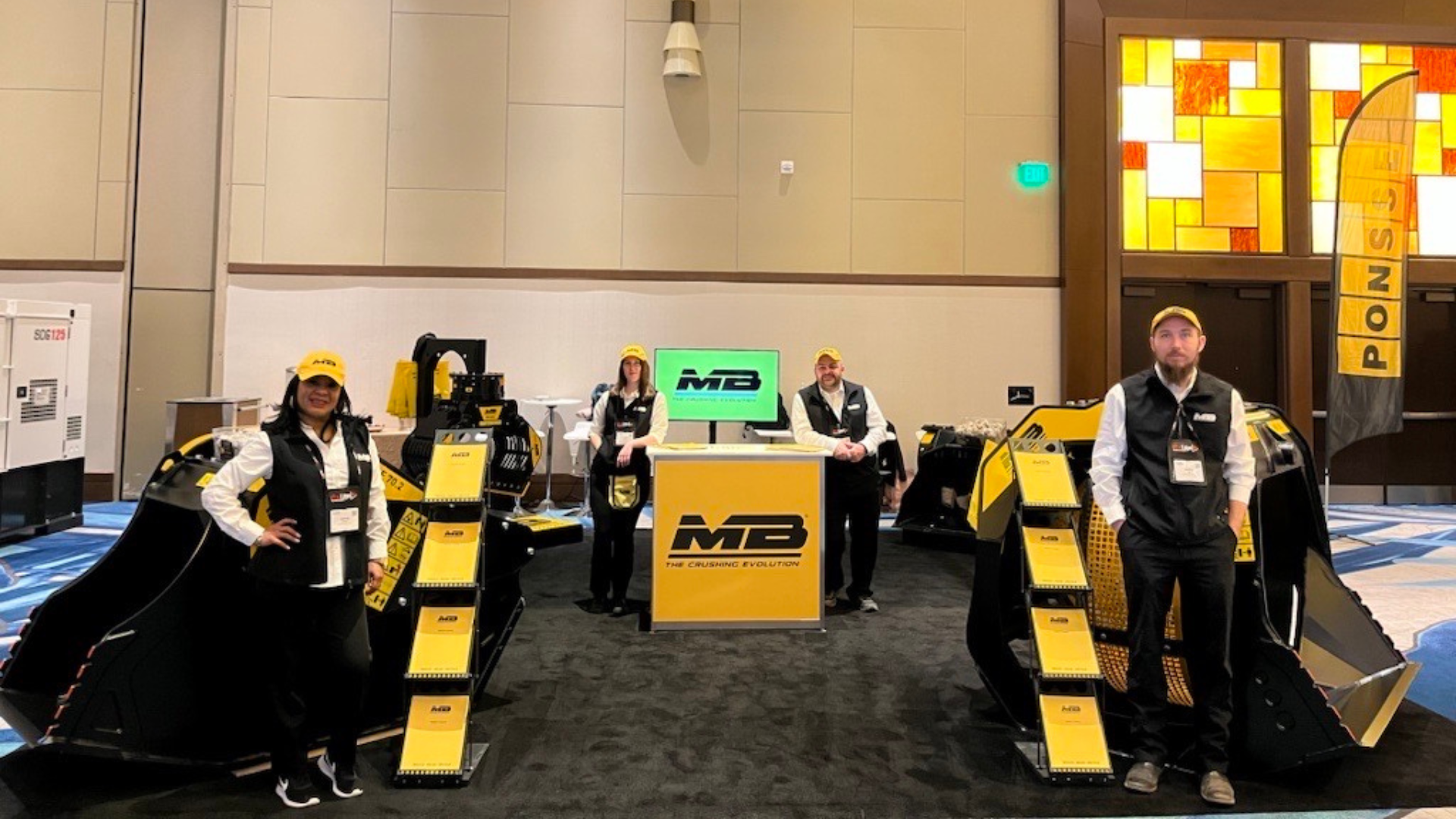 MB Crusher America Team at AED Summit exhibiting hydraulic excavator attachments.
