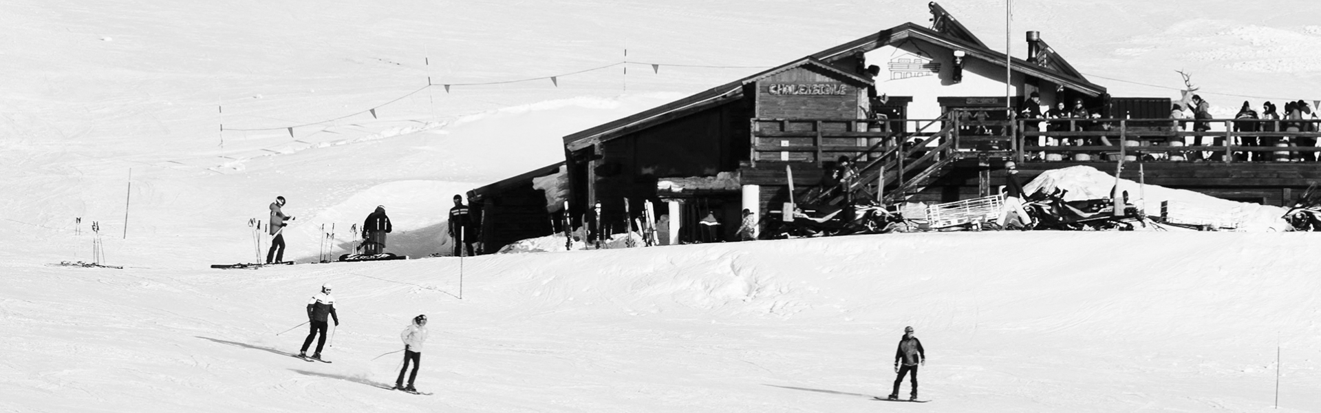 Excavator with crusher bucket working on a snowy high-altitude jobsite.
